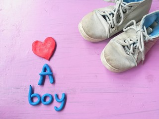 Plasticine clay dough made are cute red heart, ue a boy text and boys sneakers on pink background,  lovely wallpaper