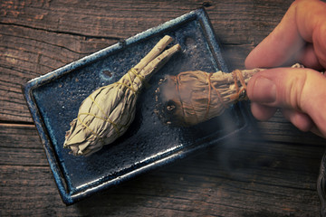 Man burning white sage incense