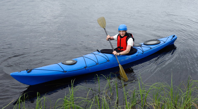Happy young man kayaking on big lake