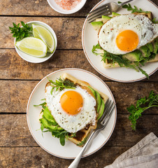 savory waffles with avocado, arugula and fried egg for breakfast