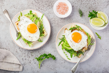 savory waffles with avocado, arugula and fried egg for breakfast