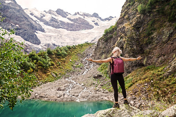 Woman stand in the mountains near the lake