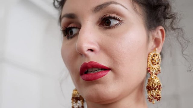 portrait of an elegant young woman with red lips in beautiful chic earrings close-up