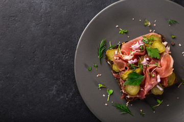 open sanwiches with dark rye bread, smoked meat, pickled cucumber  and red onion