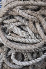 Fototapeta na wymiar Old twisted rope bundle at sea port; close-up