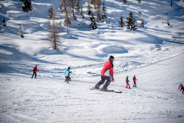 Skiers and ski track on a sunny day in the Alps