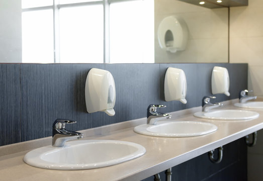 Public restroom with sinks faucets and mirror