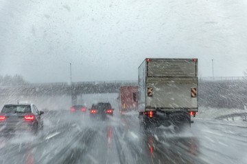 highway with cars in winter with snow fall