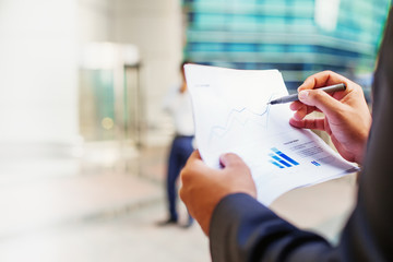 Fact sheet of a mutual fund with graphs in a hand of businessman