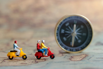 Miniature people: Traveller riding a motorcycle on map with compass, Concept of Travel around the world and the adventure.