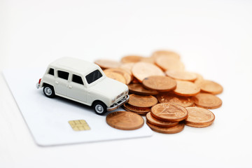 Miniature car model on credit card with coins. Concept of money, finance and car loan.