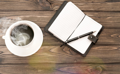 a cup of coffee. notebook, notebook, pen on the background of a wooden table. planning. business.