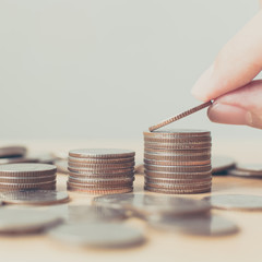 Hand putting coins stack. Save money and investment concept