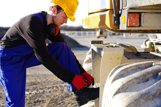 Arbeiter binden seine Arbeitsschuhe 