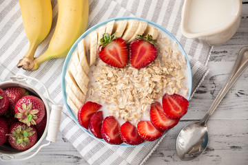 Oatmeal in bowl with strawberries and bananas