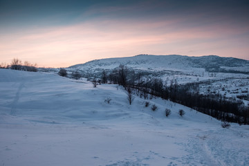 snowy hill at colorful sunset