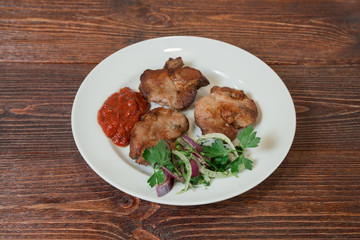 Roasted pork neck on a plate. Appetizing dish on the wooden brown table.