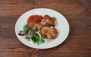 Roasted pork neck on a plate. Appetizing dish on the wooden brown table.