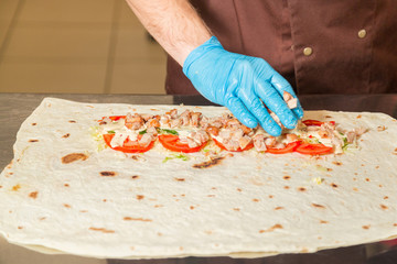 Cooking Shawarma. Unfolded view closeup. High-calorie food.