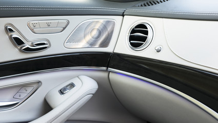 AC Ventilation Deck Luxury Car Interior. Door handle with Power seat contol buttons of a luxury passenger car. White leather interior of the luxury modern car.