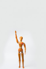 Wooden model character of woman standing and raise hand alone with one heart shape in her heart white background.Lonely woman waiting for love or broken heart concept for Valentine's day season.