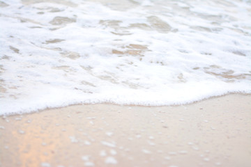 Fototapeta na wymiar White waves blowing into the beach.