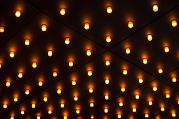 Countless glowing lightbulbs on ceiling