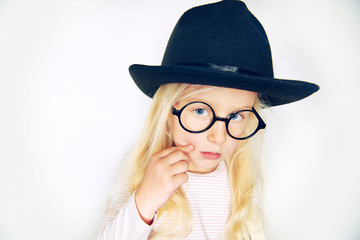 Little stylish girl in hat and glasses