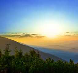 mountain slope in a blue mist at the sunset