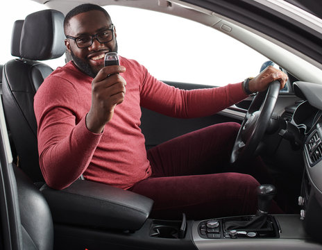 Happy Handsome African Man Showing Car Keys In His Newly Bought Auto Smiling Cheerfully Sitting In The  Luxury Vehicle Copyspace Owner Ownership Sales Driving Consumerism Private Taxi Concept