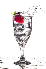 Strawberry splashing into glass of water