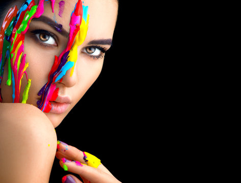 Beauty model girl with colorful paint on her face. Portrait of beautiful woman with flowing liquid paint isolated on black