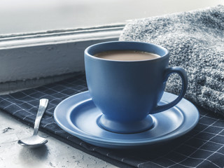 Blue coffee cup on the windowsill
