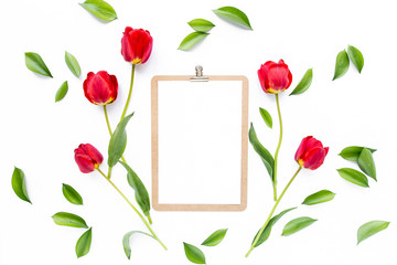 Clipboard mock up with beautiful red tulips isolated on white background. Flat lay, top view. Minimalistic office desk. Beauty blog concept.