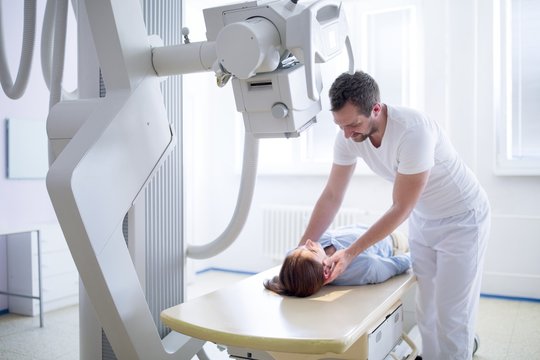 Doctor adjusting patient's neck before an x-ray