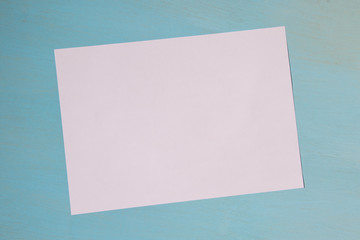 White sheet of paper on a blue background with a place for the inscription, copyspace