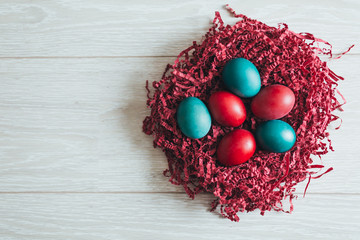 Easter eggs on wooden background in nest
