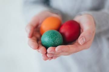 Hands holding modern easter eggs painted in colorful.