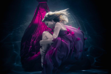 Beautiful woman swimming with fancy dress underwater