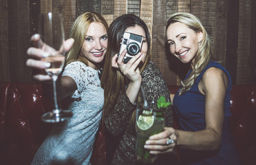 Party girls in a restaurant celebrating with drinks and champagne