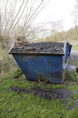 Abfallcontainer der mit klärschlamm gefüllt ist. Der container ist übervoll, der schlamm könnte...