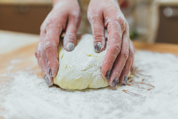 Making dough by female hands at bakery