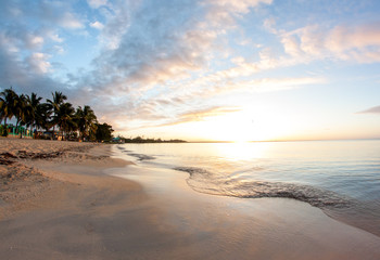 Fototapeta na wymiar Karibik Sonnenaufgang am Strand mit Palmen in Kuba