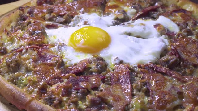 Delicious Turkish and Arabic Traditional Ramadan Food Pide, Lahmacun and Turkish Pizza serving with egg on rotating plate. Round, thin piece of dough topped with minced meat, vegetables and herbs