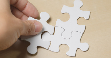 Obraz premium Hand put the piece of jigsaw puzzle