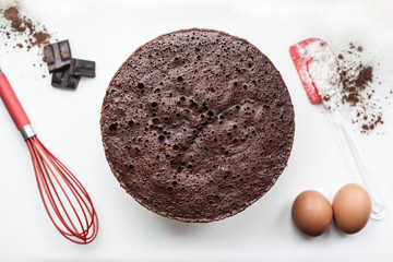 Bakery ingredients - flour, eggs, cocoa, chocolate on white table. Sweet pastry baking concept. Flat lay, copy space, top view