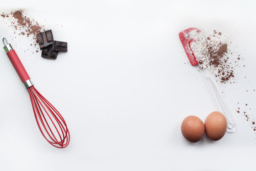 Bakery ingredients - flour, eggs, cocoa, chocolate on white table. Sweet pastry baking concept....