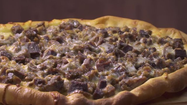 Turkish and Arabic Traditional Baked Ramadan Food Pide or Pizza ingredients with sliced halal lamb meat , butter, cheese and spicy herbs. Rotating shot.