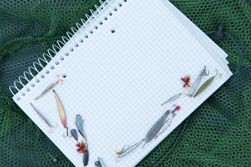 paper notebook with fishing accessories and space for text