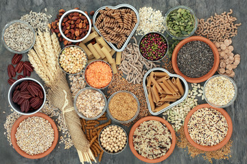 Healthy high fibre dietary food concept with whole wheat pasta, legumes, nuts, seeds, cereals,...